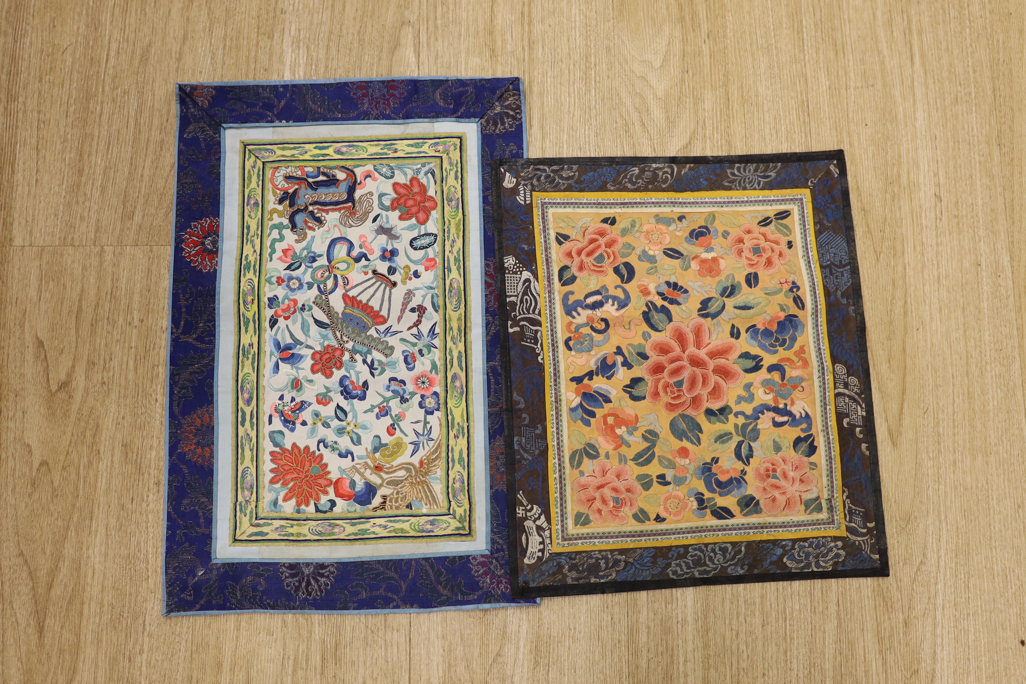 Six Chinese silk embroidered panels, embroidered with Beijing knot and stem stitch, using auspicious symbols: figures, flowers, butterflies and one with a dragon, five bordered with silk brocade, largest 48cm high x 32cm